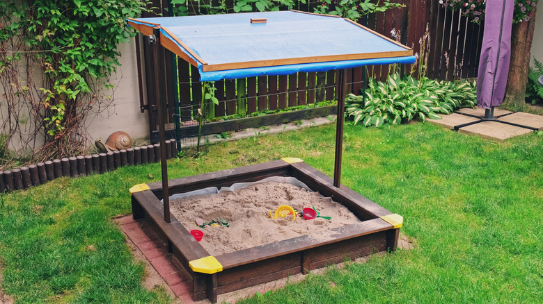 Kids Sandbox with Blue Canopy Roof Built in Backyard Garden