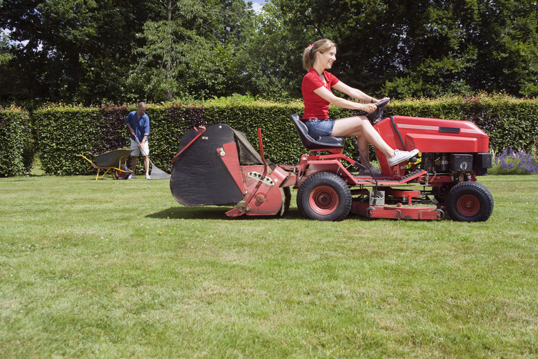 Woman using riding mower.