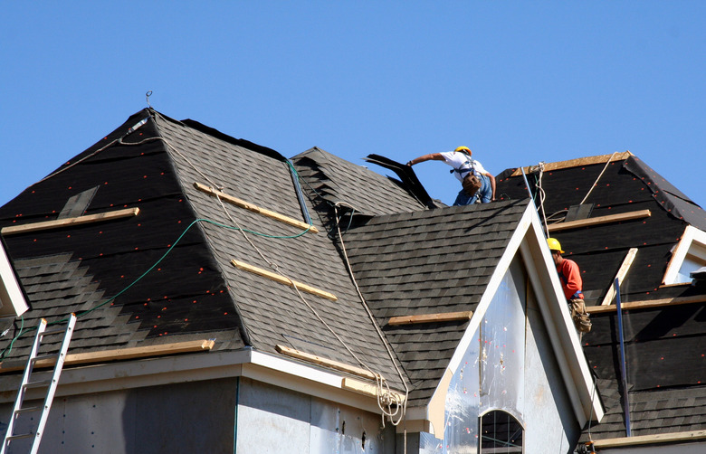 Roof Workers on top of house with blue sky