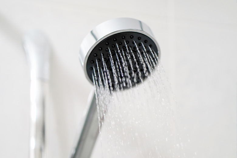 Shower head in bathroom with water spray or water flow. Fresh water flow from shower head for cleaning body.