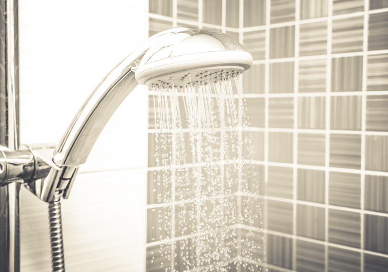 Fresh shower where water running from shower head and faucet in modern bathroom. Sepia