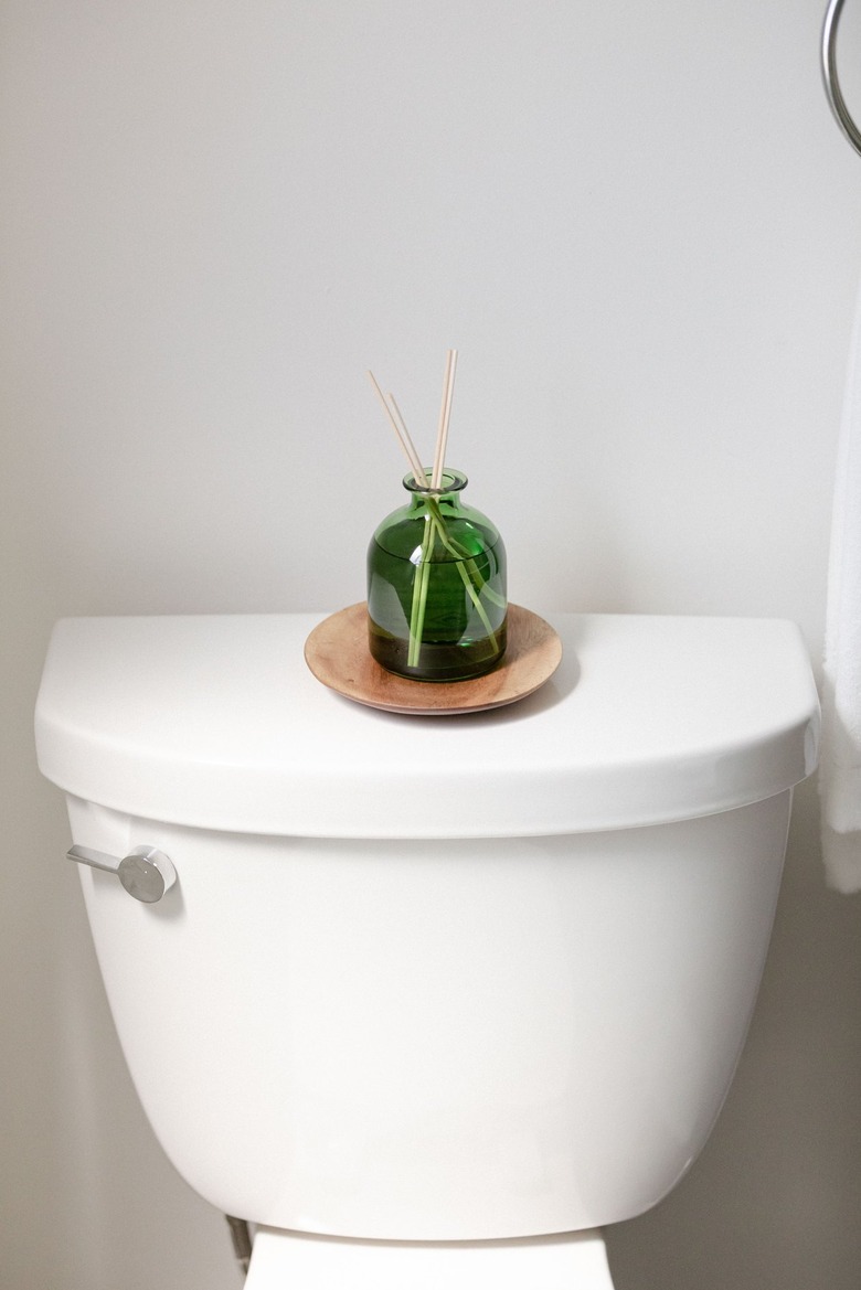 glass diffuser on top of white toilet