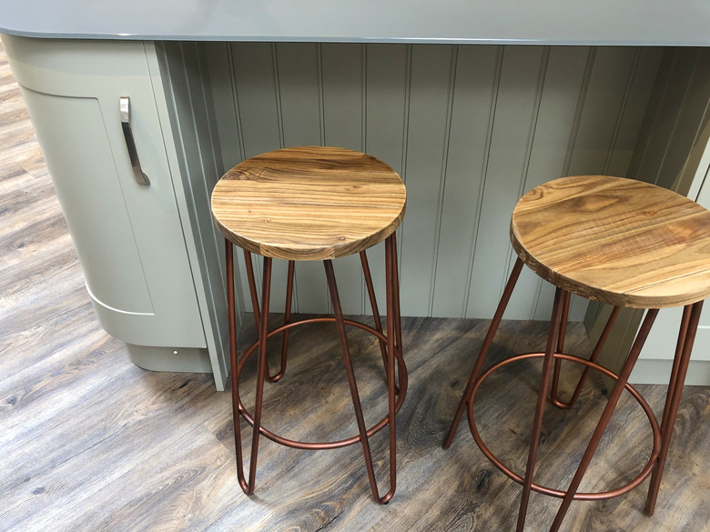 Image of curved kitchen floor cabinets painted duck egg blue, breakfast bar / kitchen island tongue and groove cladding timber, grey composite corian worktop countertop, oak wood stools with copper coloured metal legs on dark oak effect laminate floors