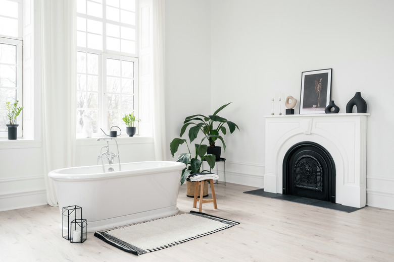 Contemporary white bathroom with houseplants and freestanding bathtub.