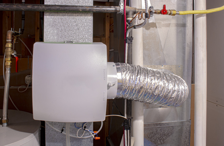 A home humidifier attached to the return duct with a bypass connection to the supply hot air duct.