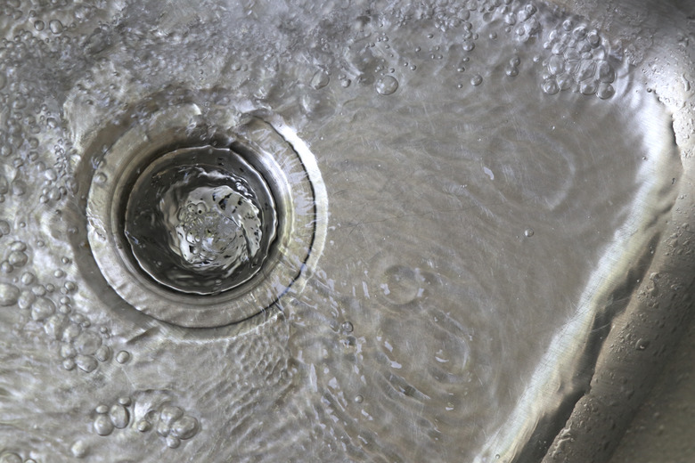 The water in the sink is flowing into the drain.