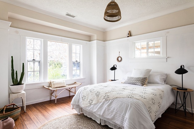 Boho white-walled bedroom with wood floors and woven decorative furnishings