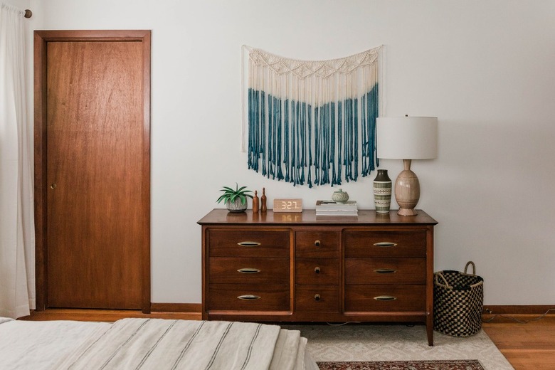 Bohemian blue and white macrame wall hanging over dresser in bedroom