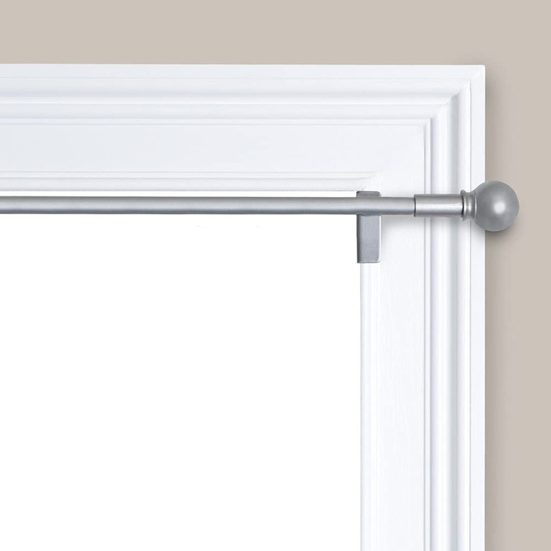 A white door with a twist-and-fit curtain rod on it