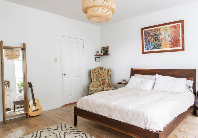 Bedroom with hanging light fixture and full length mirror