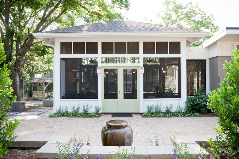 A painted screen door on an expansive screened-in porch