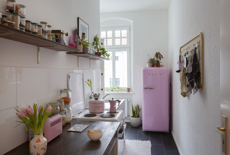 galley-style kitchen with pink accents and pink fridge