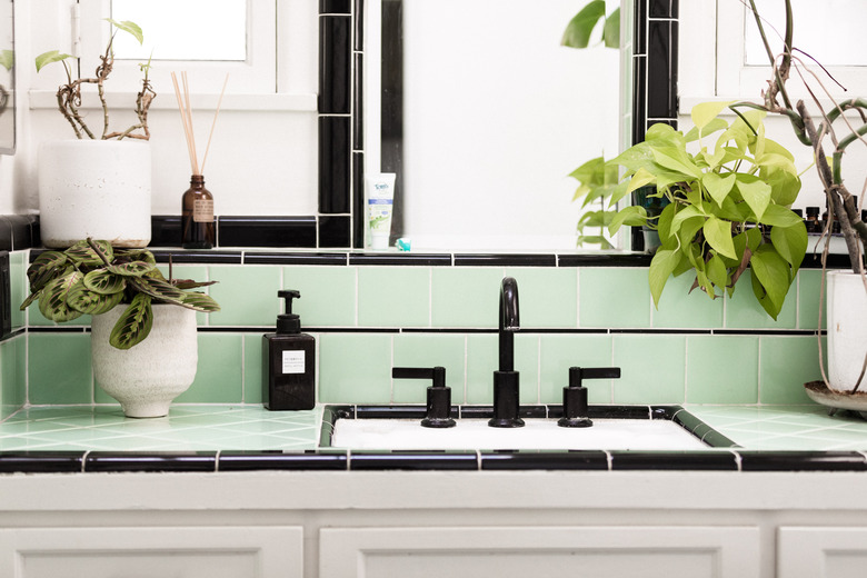 bathroom countertop with blank sink and green and black tiling