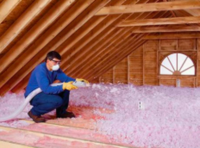 Blowing attic insulation.