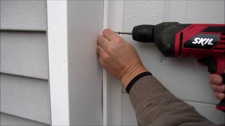 Installing garage door weatherstripping.