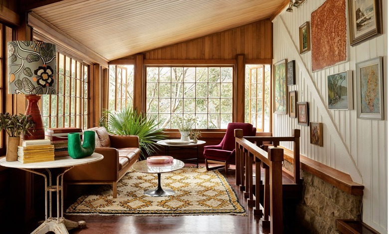 corner sitting room with knotty pine walls, and doses of pattern