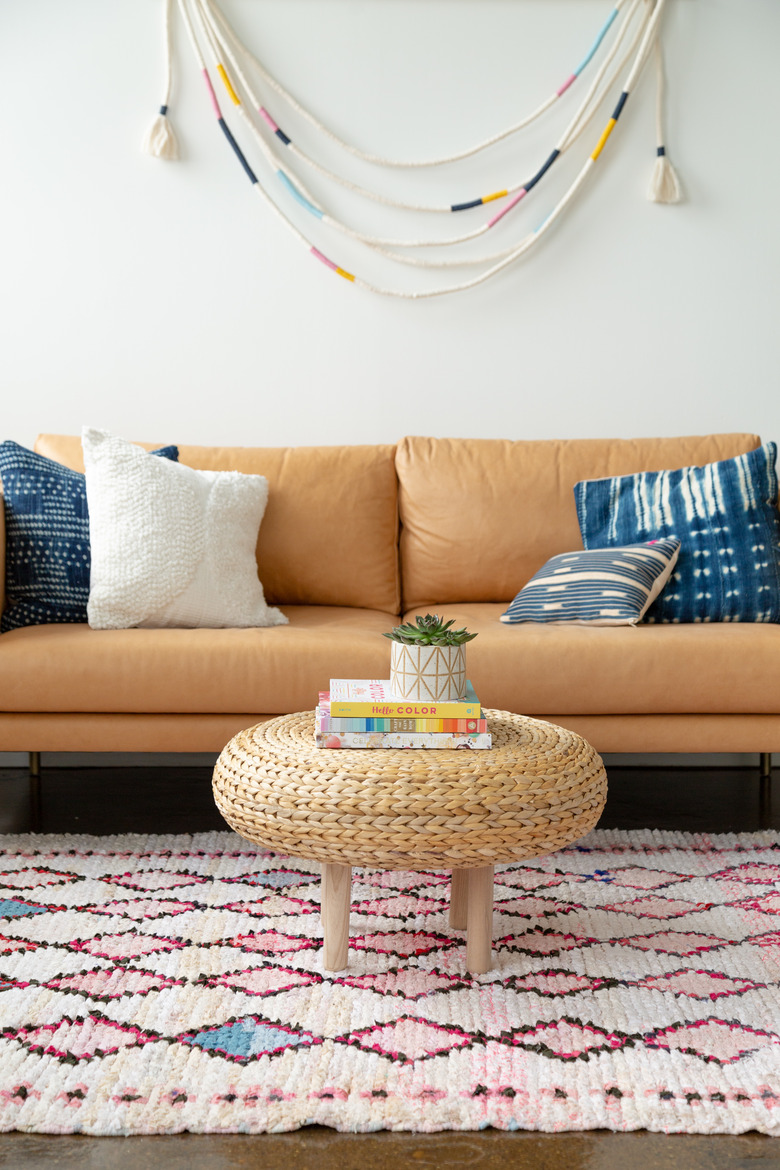 ikea hack of IKEA Alseda stool turned into a coffee table with an orange coach and diamond rug