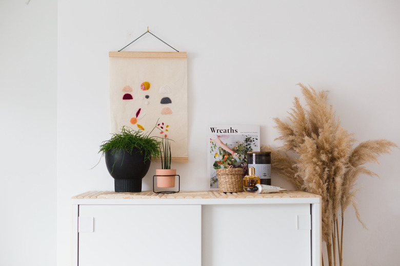 ikea hack of Mackapär shoe cabinet turned into bedroom storage with wooden dowels and plants