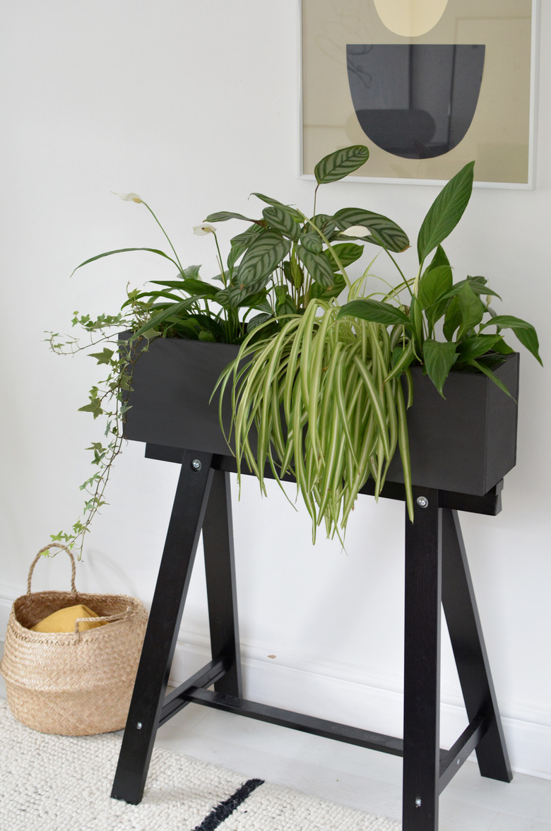 ikea hack of the IKEA Oddvald trestle turned into a black plant stand