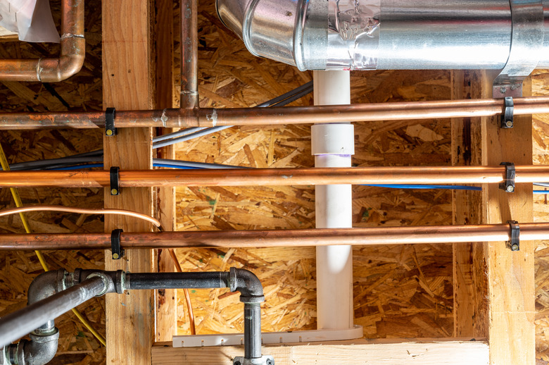 Ceiling with multiple utility lines - gas, electrical, water, internet, and sewer.