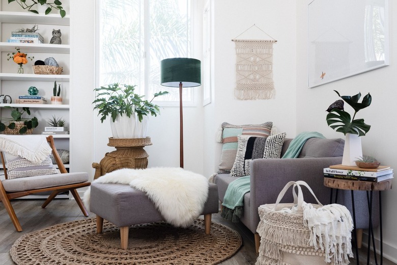 Gray-white furniture in a living room with plants and Boho decor