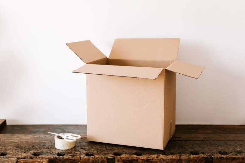 cardboard box on table with tape and scissors