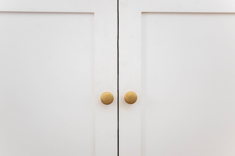 Knobs painted brass and attached to cabinet