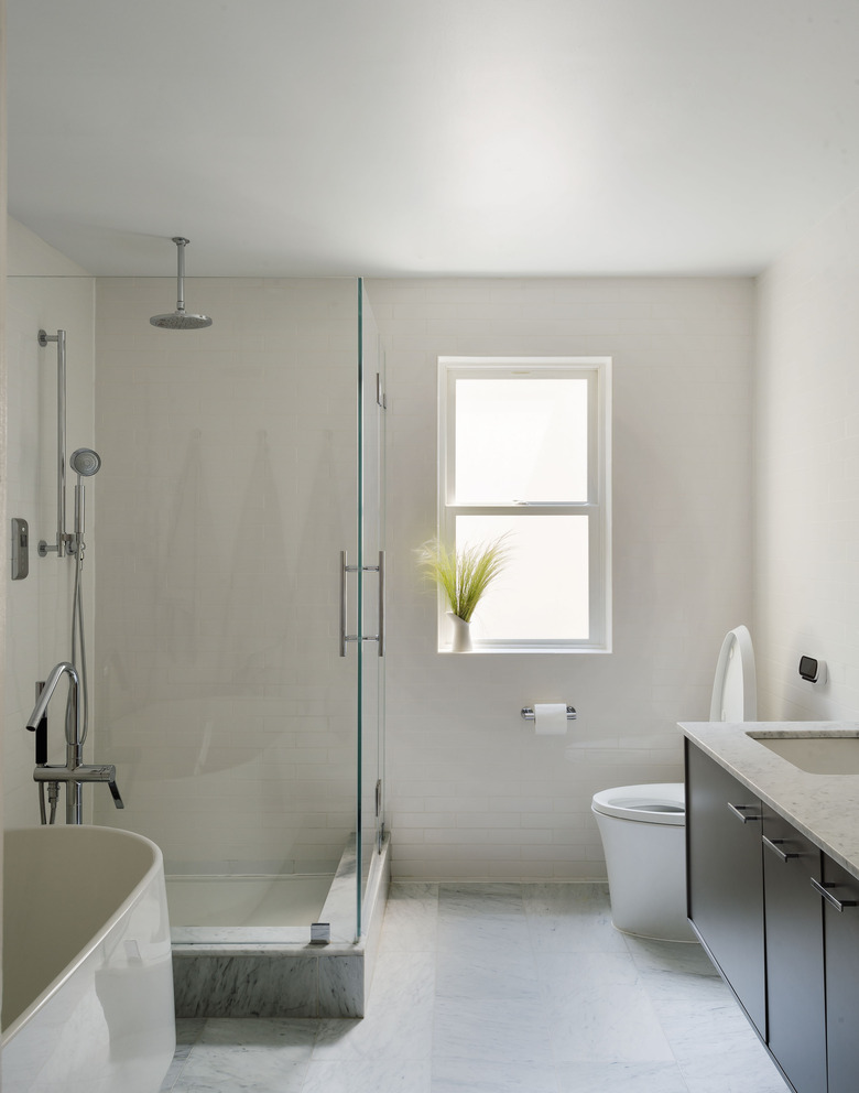 minimalist bathroom with separate tub and glass shower