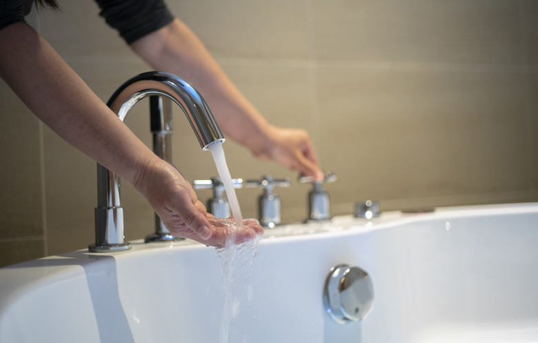 turning on the water of bathtub