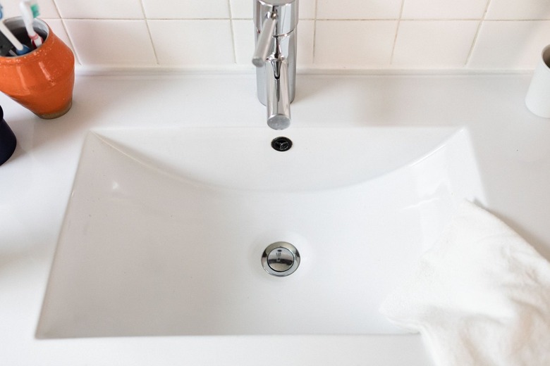 closeup of white sink with silver single-handle faucet