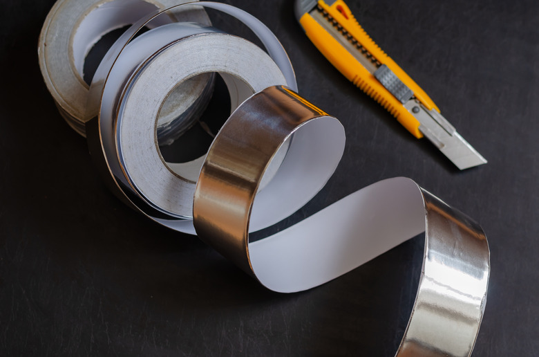 Aluminum insulation tape on a dark table.