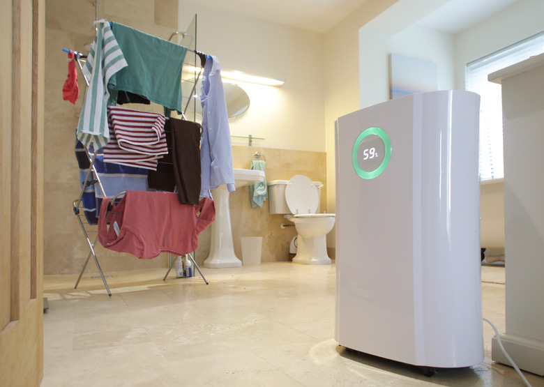 Dehumidifier in bathroom with drying clothes