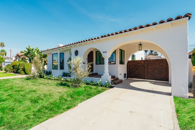 Spanish house, front yard, lawn, arch driveway, gate.