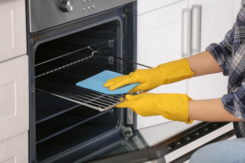 Woman cleaning oven in kitchen, closeup