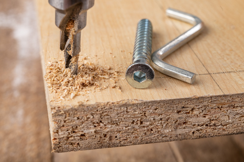 Tools and screws used in carpentry. Small carpentry work in the workshop. Light background.