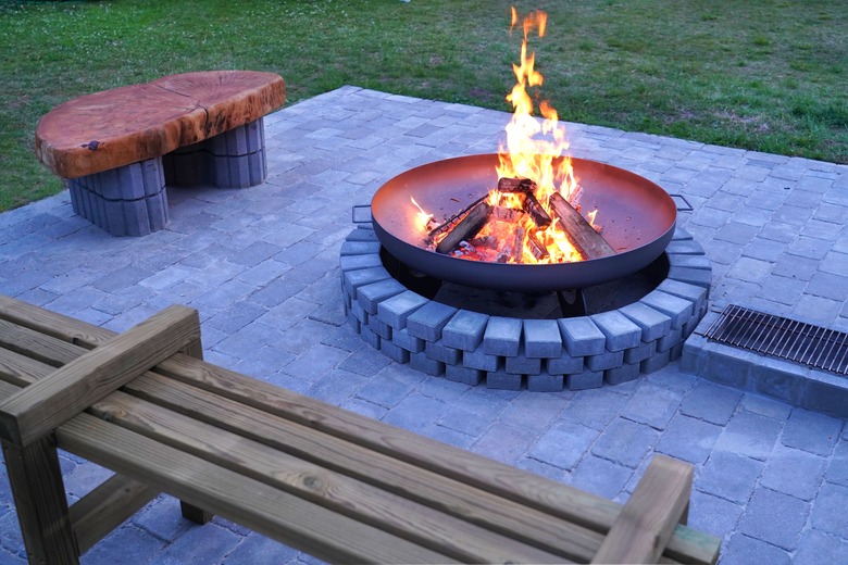 Iron firepit and burning fire on patio.