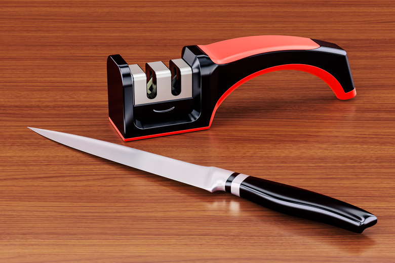 Knife with knife sharpener on the wooden table. 3D rendering