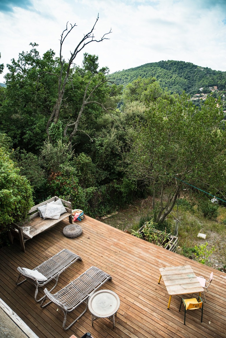 A wood deck overlooking mountains and trees with a patio furniture set