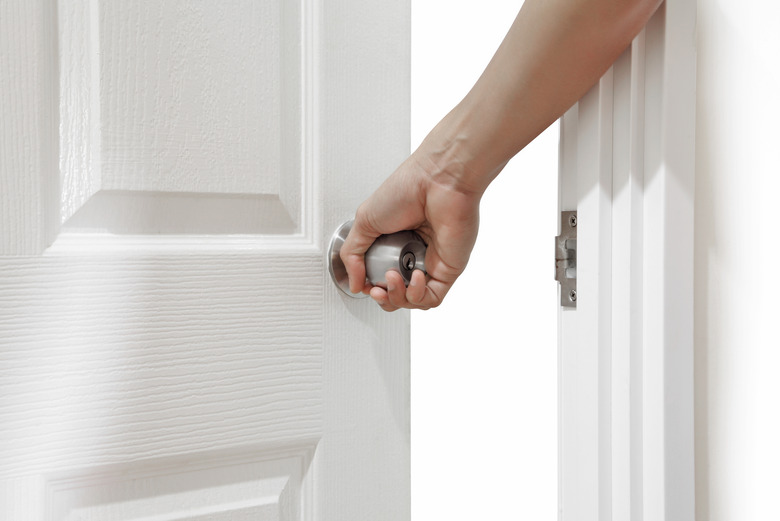 Man hand open door knob or opening white wooden door