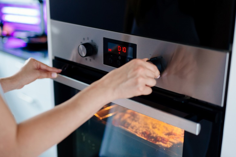 Woman regulates the time of the baking