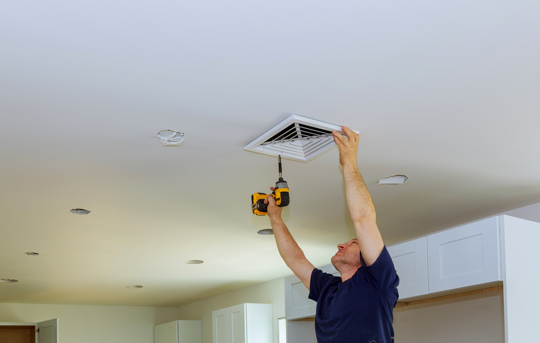 worker builder installing ventilated ventilation cover construction of building