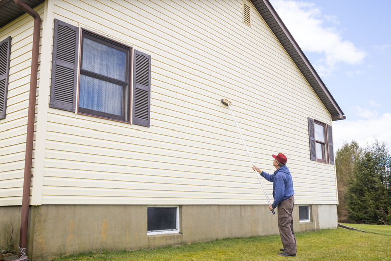 Homeowner cleaning vinyl siding.