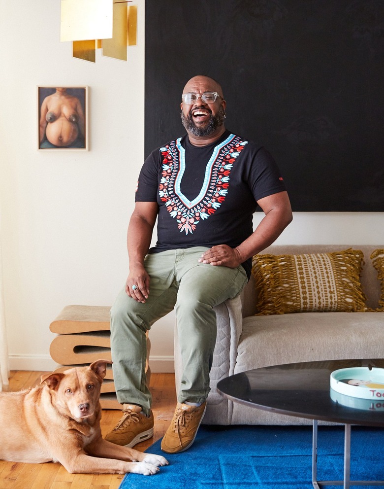 interior designer Leyden Lewis in his living room with dog