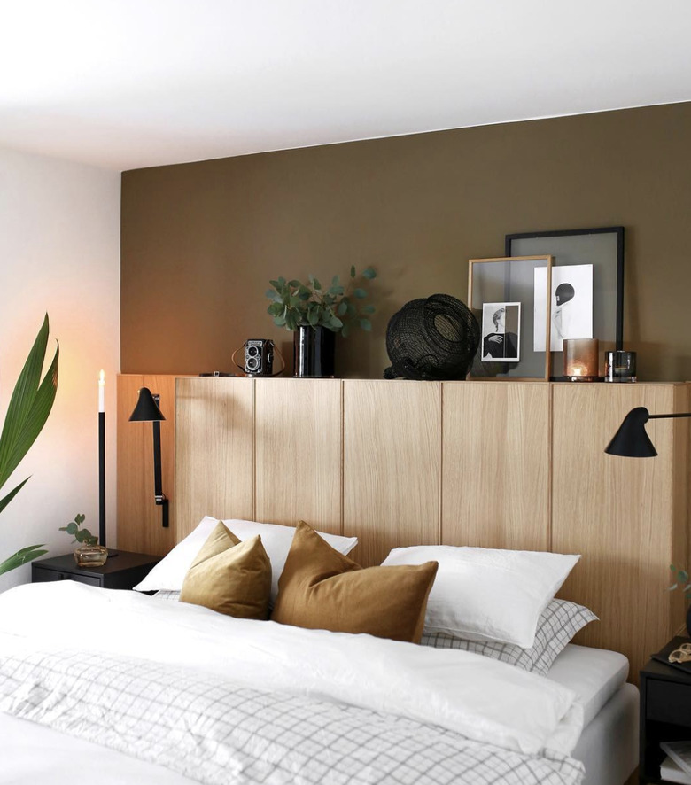 Unfinished wood cabinets used in place of a headboard on a mostly-white bed