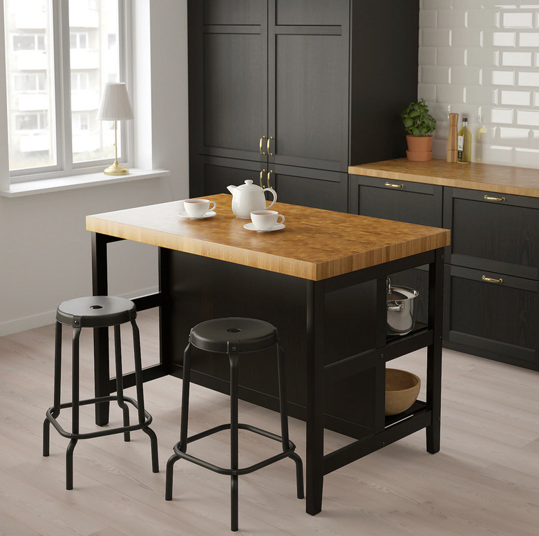 Black and oak IKEA kitchen island in modern kitchen with black cabinets