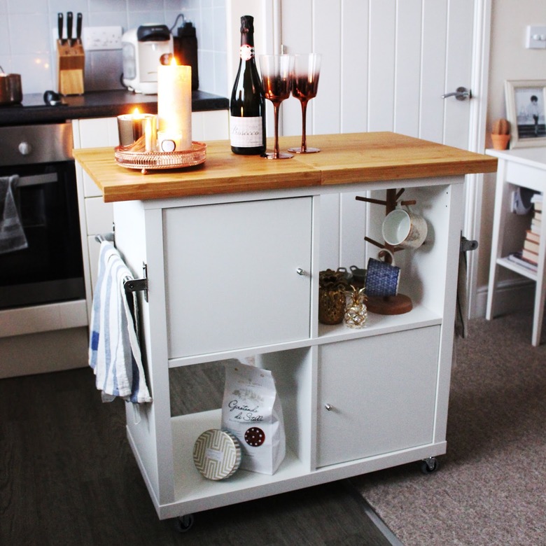 IKEA kitchen island with wood countertop and white cabinets