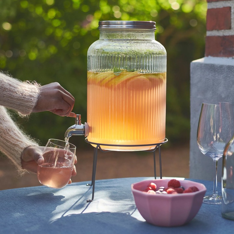 person getting a drink from beverage dispenser