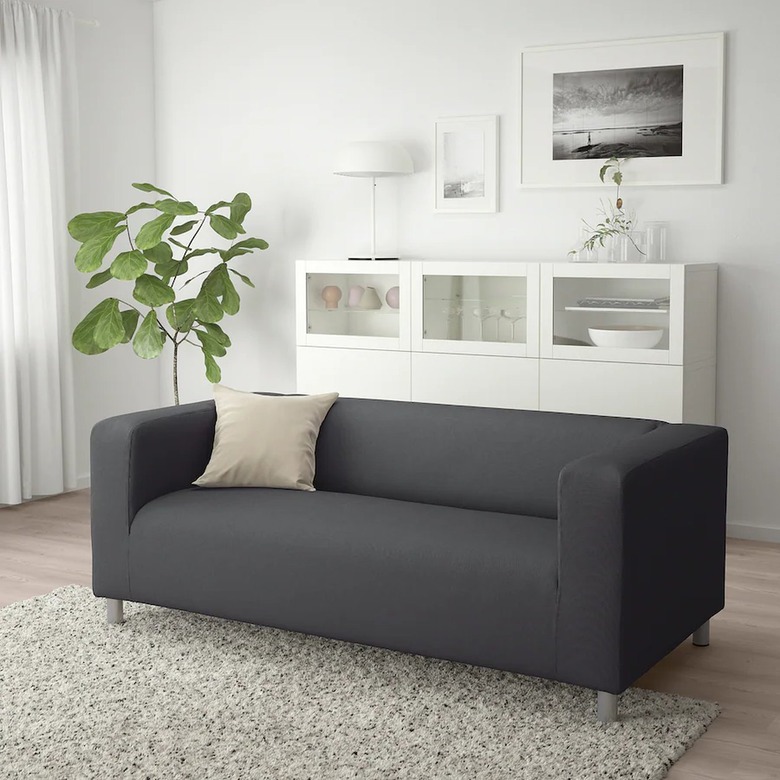 dark gray couch near white furniture and white framed artwork