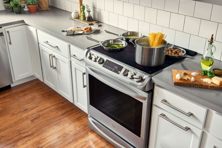 Induction stove, white cabinets, white tile backsplash.