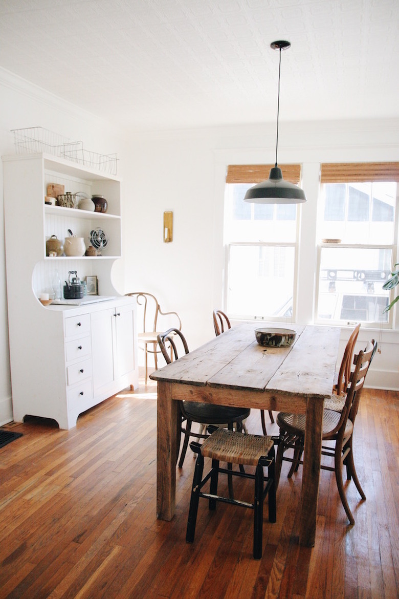 industrial dining room idea with white walls and wooden table